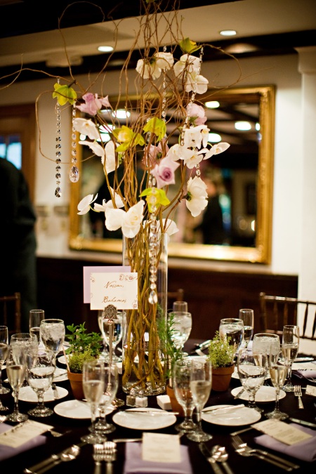 This centerpiece featured cymbidiums, phaleonopsis, and roses wired onto curly willow.